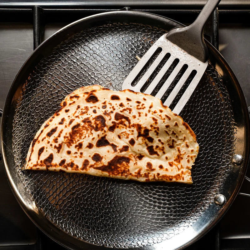 Galette dorée dans une poêle martelée en titane Maison Ferré®, soulevée à la spatule