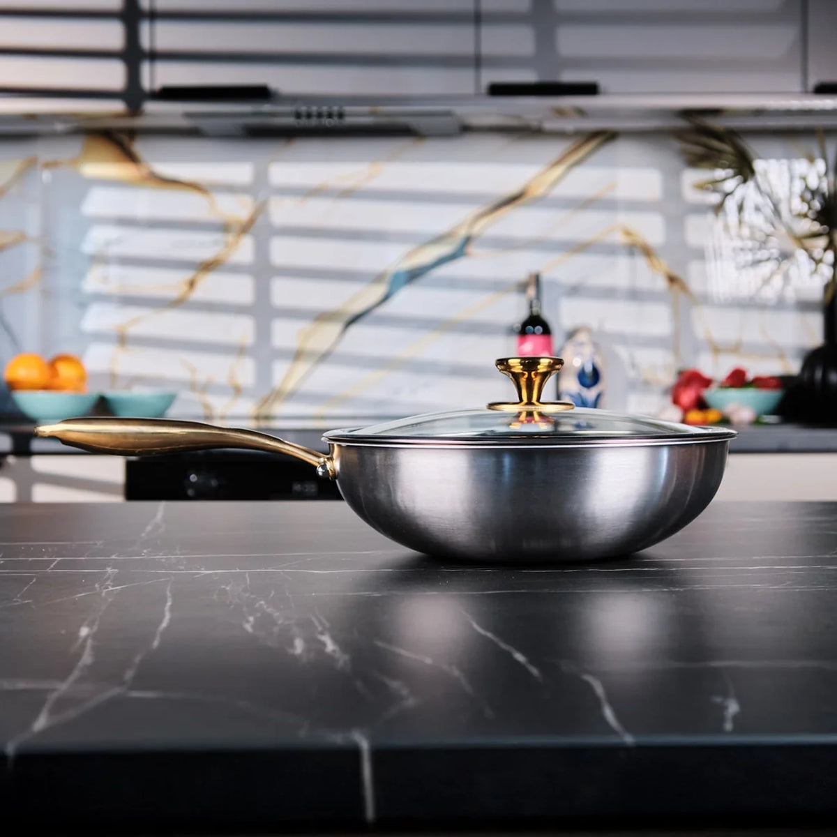 Wok en titane Maison Ferré® avec couvercle en verre sur un plan de travail en marbre
